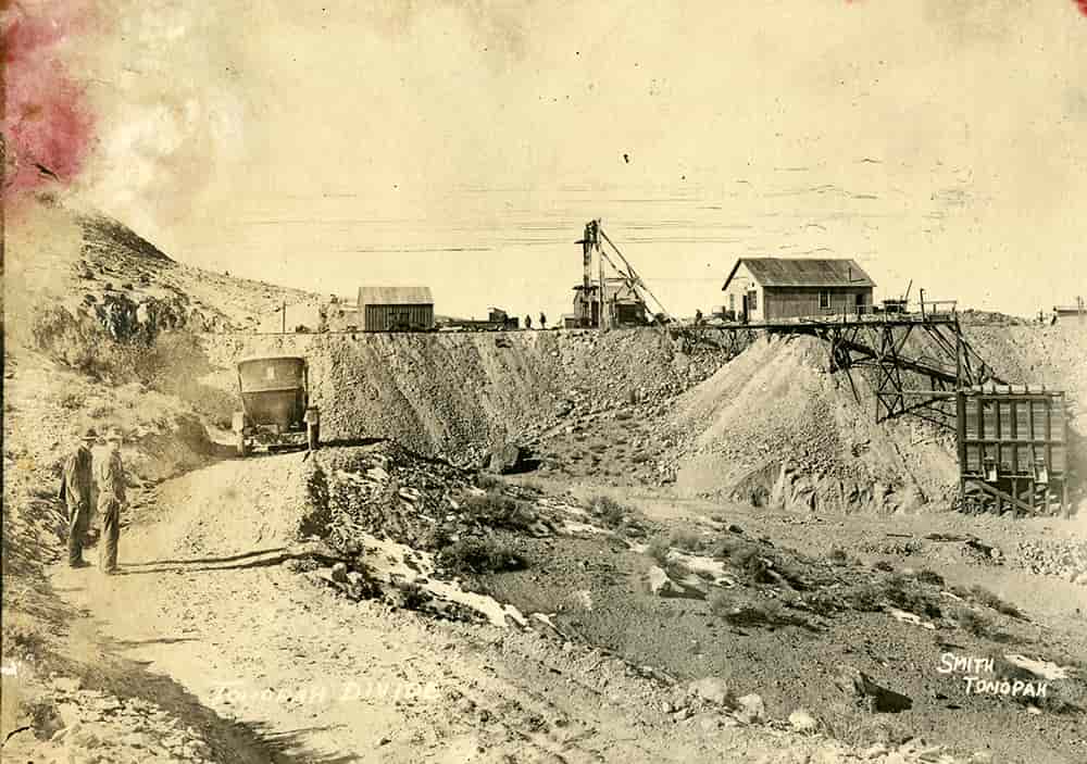Black and white photograph of men and a car at a mining site