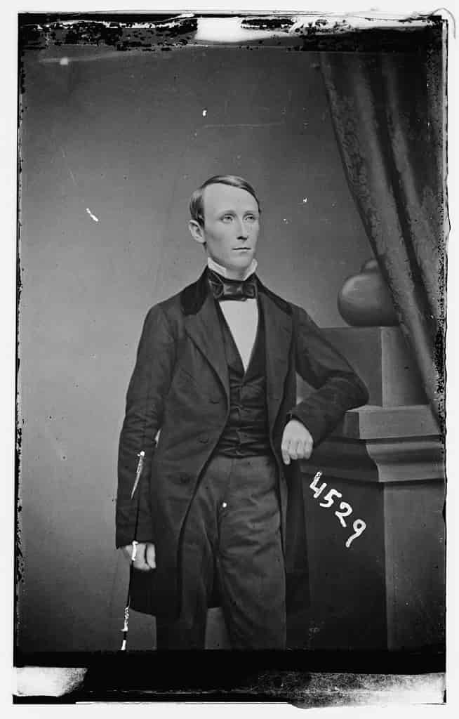 Black and white photograph of William Walker, full-length portrait in a black and white suit.